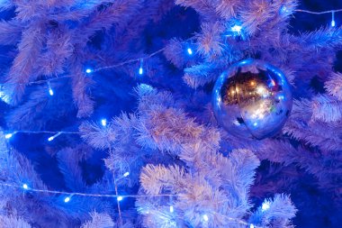 görüntü bir beyaz dekoratif Noel süs Orb beyaz çam ağacı dal mavi aydınlatma ile yakından.
