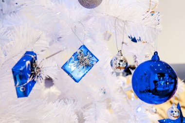 görüntü bir beyaz dekoratif Noel süs Orb beyaz çam ağacı dal mavi aydınlatma ile yakından.