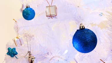 görüntü bir beyaz dekoratif Noel süs Orb beyaz çam ağacı dal mavi aydınlatma ile yakından.