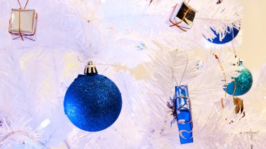 görüntü bir beyaz dekoratif Noel süs Orb beyaz çam ağacı dal mavi aydınlatma ile yakından.