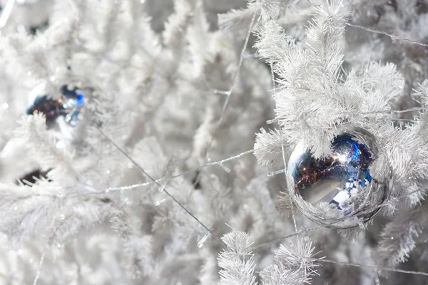 Görüntü bir beyaz dekoratif Noel süs Orb beyaz çam ağacı dal mavi aydınlatma ile yakından. — Stok fotoğraf