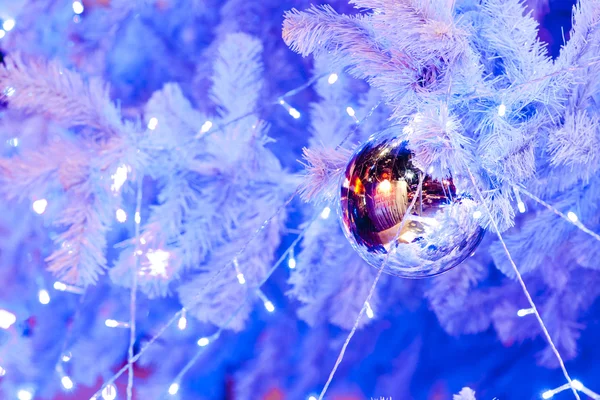 Görüntü bir beyaz dekoratif Noel süs Orb beyaz çam ağacı dal mavi aydınlatma ile yakından. — Stok fotoğraf
