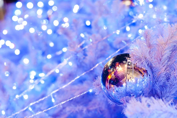 Zblízka obraz bílá dekorativní vánoční ozdobné koule na větev stromu bílé jedle s modrým osvětlením. — Stock fotografie