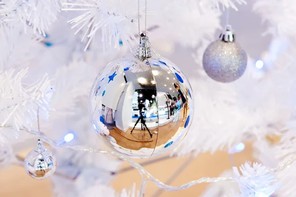 Görüntü bir beyaz dekoratif Noel süs Orb beyaz çam ağacı dal mavi aydınlatma ile yakından. — Stok fotoğraf