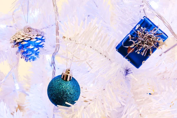 Görüntü bir beyaz dekoratif Noel süs Orb beyaz çam ağacı dal mavi aydınlatma ile yakından. — Stok fotoğraf