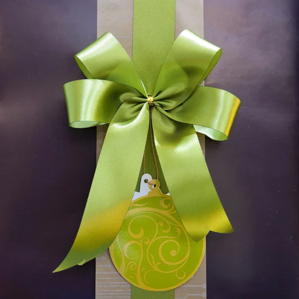 Brown gift box with green ribbon bow — Stock Photo, Image