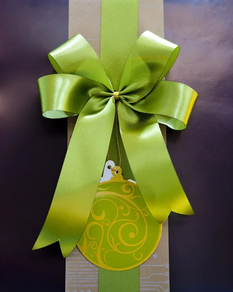 Brown gift box with green ribbon bow — Stock Photo, Image