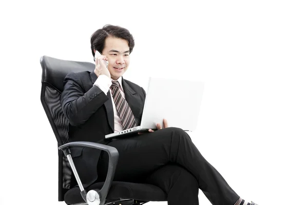 Joven hombre de negocios sonriente llamando por teléfono en la oficina . — Foto de Stock