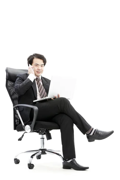 Joven hombre de negocios sonriente llamando por teléfono en la oficina . — Foto de Stock