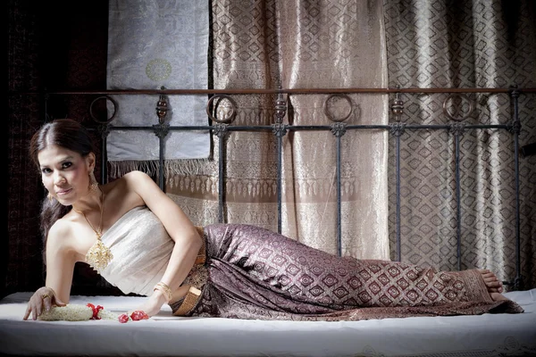 Preciosa mujer asiática en tailandés vestido acostado en la cama —  Fotos de Stock