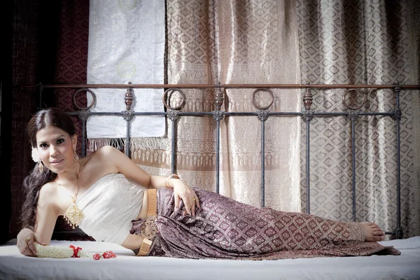 Preciosa mujer asiática en tailandés vestido acostado en la cama —  Fotos de Stock