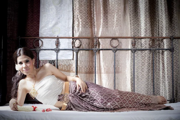 Preciosa mujer asiática en tailandés vestido acostado en la cama — Foto de Stock