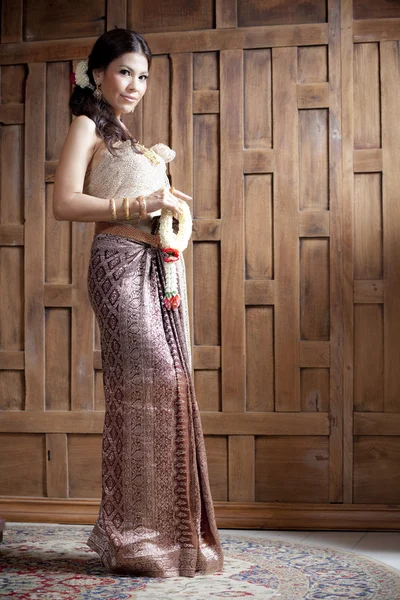 Portrait Gorgeous asian woman in thai dress near wooden wall — Stock Photo, Image