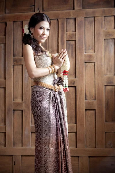 Portrait Gorgeous asian woman in thai dress near wooden wall — Stock Photo, Image