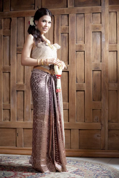 Retrato Hermosa mujer asiática en vestido tailandés cerca de la pared de madera — Foto de Stock