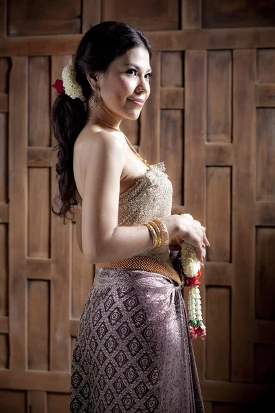 Portrait Magnifique femme asiatique en robe thaï près du mur en bois — Photo