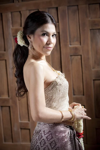 Portrait Gorgeous asian woman in thai dress near wooden wall — Stock Photo, Image