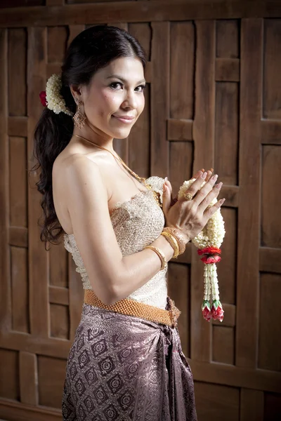 Retrato lindo ásia mulher no tailandês vestido perto de madeira parede — Fotografia de Stock