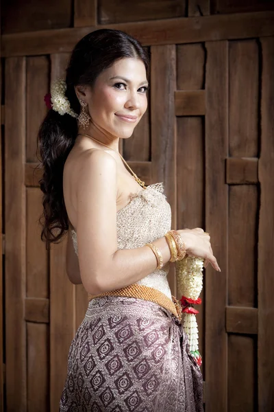 Retrato Hermosa mujer asiática en vestido tailandés cerca de la pared de madera — Foto de Stock