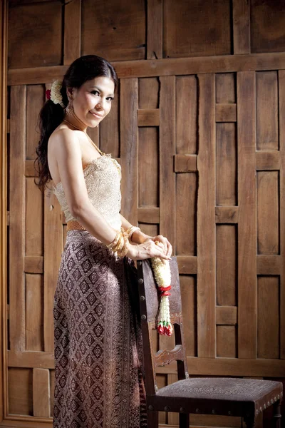 Portrat prachtige Aziatische vrouw in Thaise jurk met stoel — Stockfoto