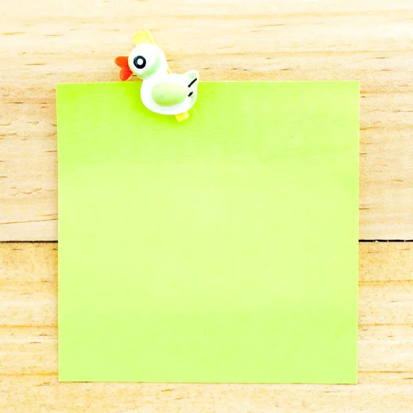 Carta bianca verde con la clip sullo sfondo di legno — Foto Stock