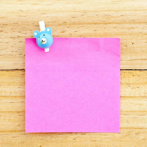 Růžový prázdný papír s klipem na dřevěné pozadí — Stock fotografie