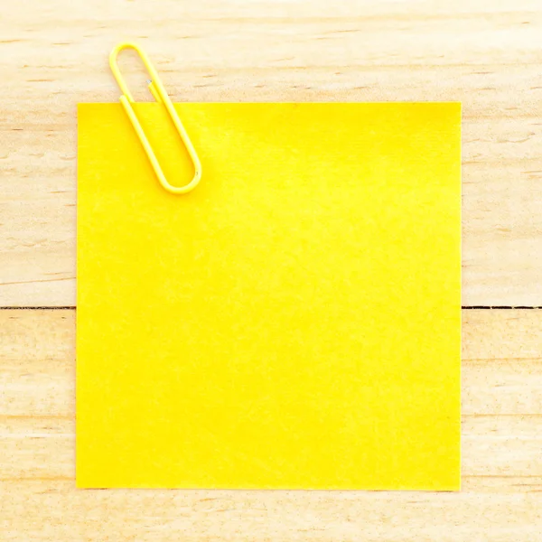 Żółty papier blank z klipem na drewniane tła — Zdjęcie stockowe