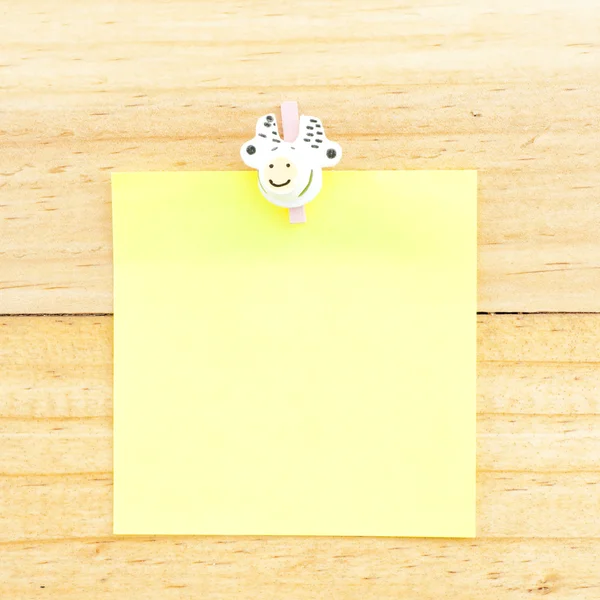 Желтая пустая бумага с зажимом на деревянном фоне — стоковое фото