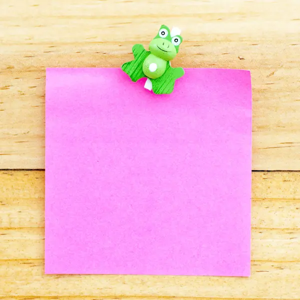 Růžový prázdný papír s klipem na dřevěné pozadí — Stock fotografie