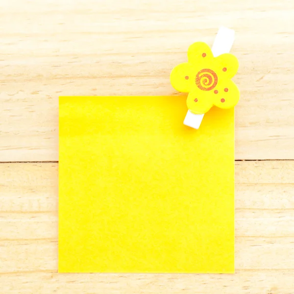 A klip a fából készült háttér sárga üres papír — Stock Fotó