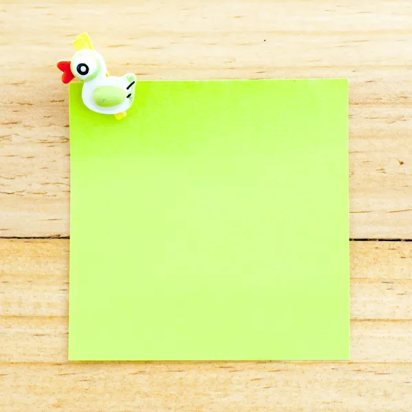 Carta bianca verde con la clip sullo sfondo di legno — Foto Stock