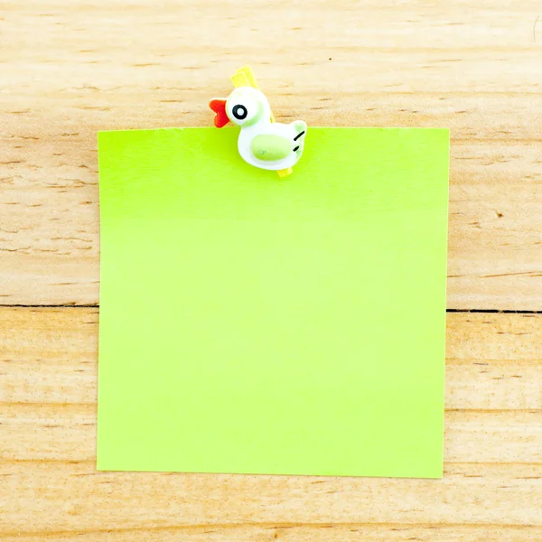 Зеленая пустая бумага с зажимом на деревянном фоне — стоковое фото