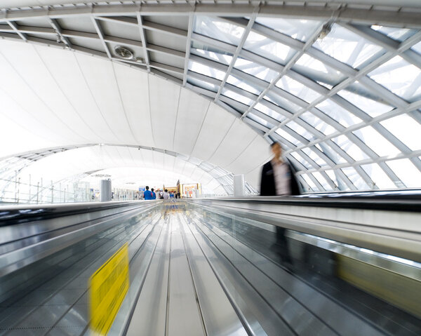 Люди, мчащиеся к эскалатору в движении размыты
