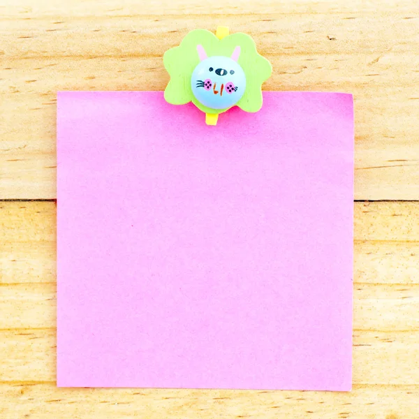 Carta bianca rosa con la clip sullo sfondo di legno — Foto Stock