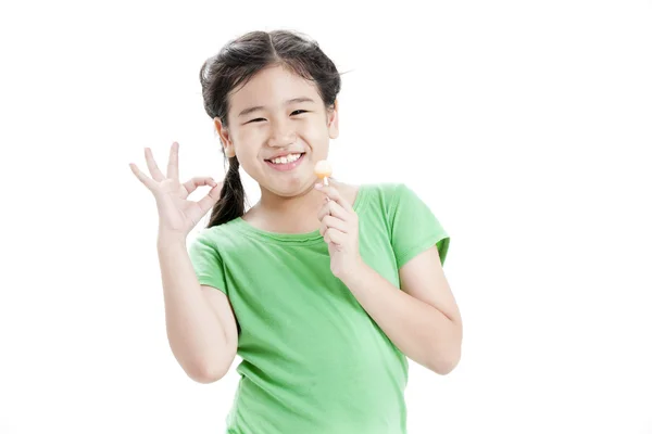 Poco lindo divertido chica asiática con colorido caramelo piruleta —  Fotos de Stock