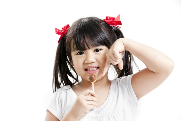 Kleine süße lustige asiatische Mädchen mit bunten Lutschbonbons — Stockfoto