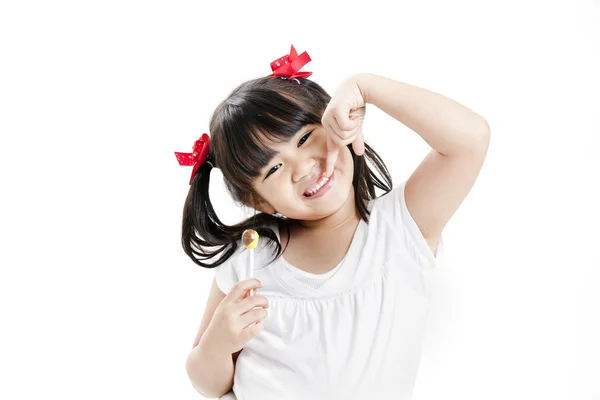 Маленькая забавная азиатская девочка с красочными конфетками леденец — стоковое фото