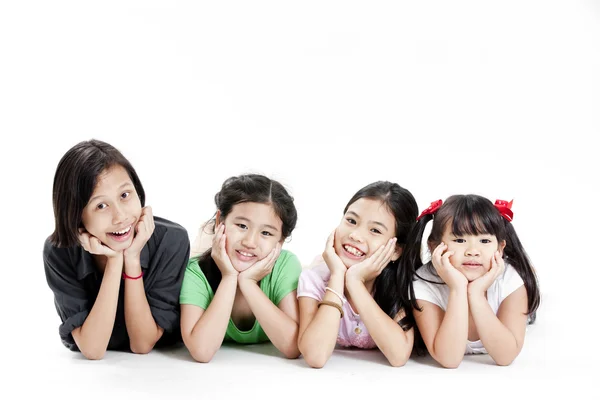 Group of little asian girls lying on floor isolated on white — Stock Photo, Image