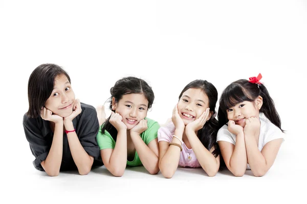 Zemin üzerinde beyaz izole yatan küçük Asyalı kızlar grup — Stok fotoğraf