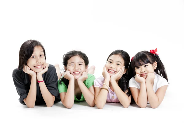 Group of little asian girls lying on floor isolated on white — Stock Photo, Image