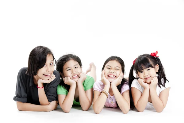 Group of little asian girls lying on floor isolated on white — Stock Photo, Image