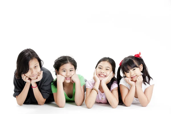 Groep van Aziatische meisjes liggend op vloer geïsoleerd op wit — Stockfoto