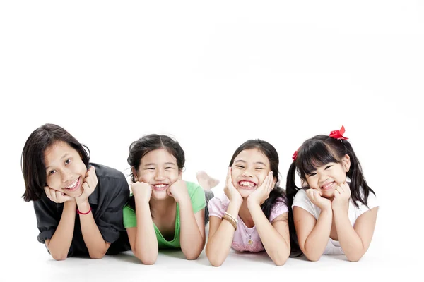 Sekelompok gadis Asia kecil tergeletak di lantai terisolasi di atas putih — Stok Foto