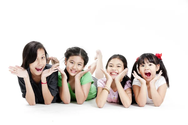 Grupo de meninas asiáticas pouco deitado no chão isolado no branco — Fotografia de Stock
