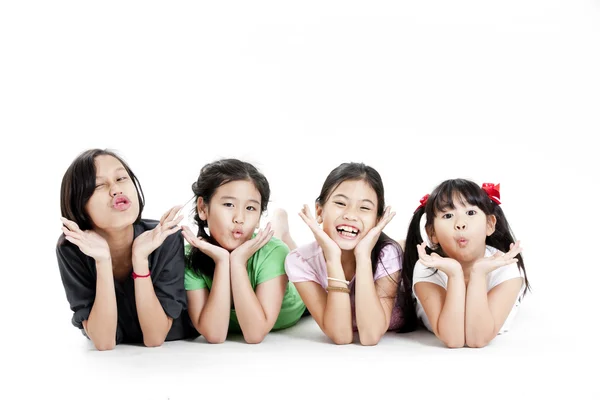 Zemin üzerinde beyaz izole yatan küçük Asyalı kızlar grup — Stok fotoğraf