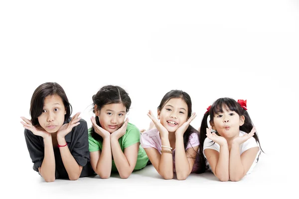 Group of little asian girls lying on floor isolated on white — Stock Photo, Image