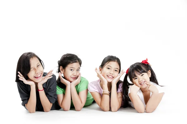 Grupo de niñas asiáticas tumbadas en el suelo aisladas en blanco —  Fotos de Stock