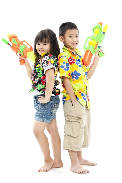 Девочка и мальчик с водяными пистолетами — стоковое фото