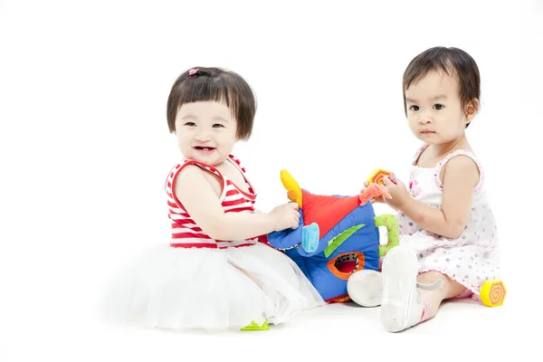 Porträtt av två söta asiatiska tjejer leker med leksak — Stockfoto