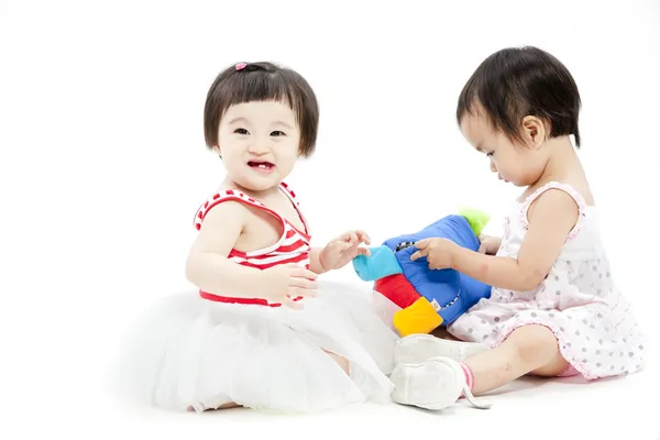 Portrait of two cute asian girls playing with toy — Stock Photo, Image